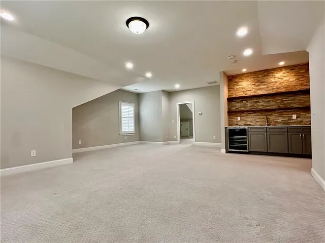 an empty room with stainless steel appliances with kitchen view