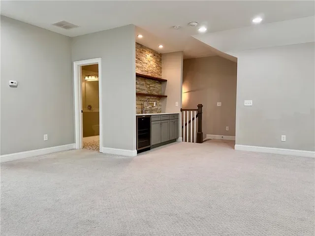 an empty room with kitchen and stainless steel appliances