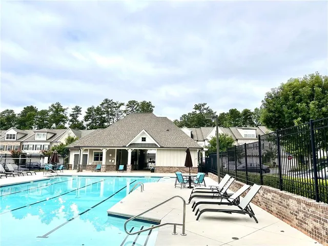 a view of a house with swimming pool and sitting area