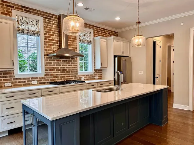 a kitchen with stainless steel appliances granite countertop a sink a stove and a refrigerator