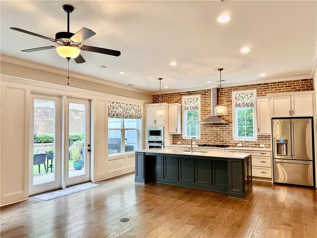 a view of kitchen with stainless steel appliances granite countertop cabinets and a table