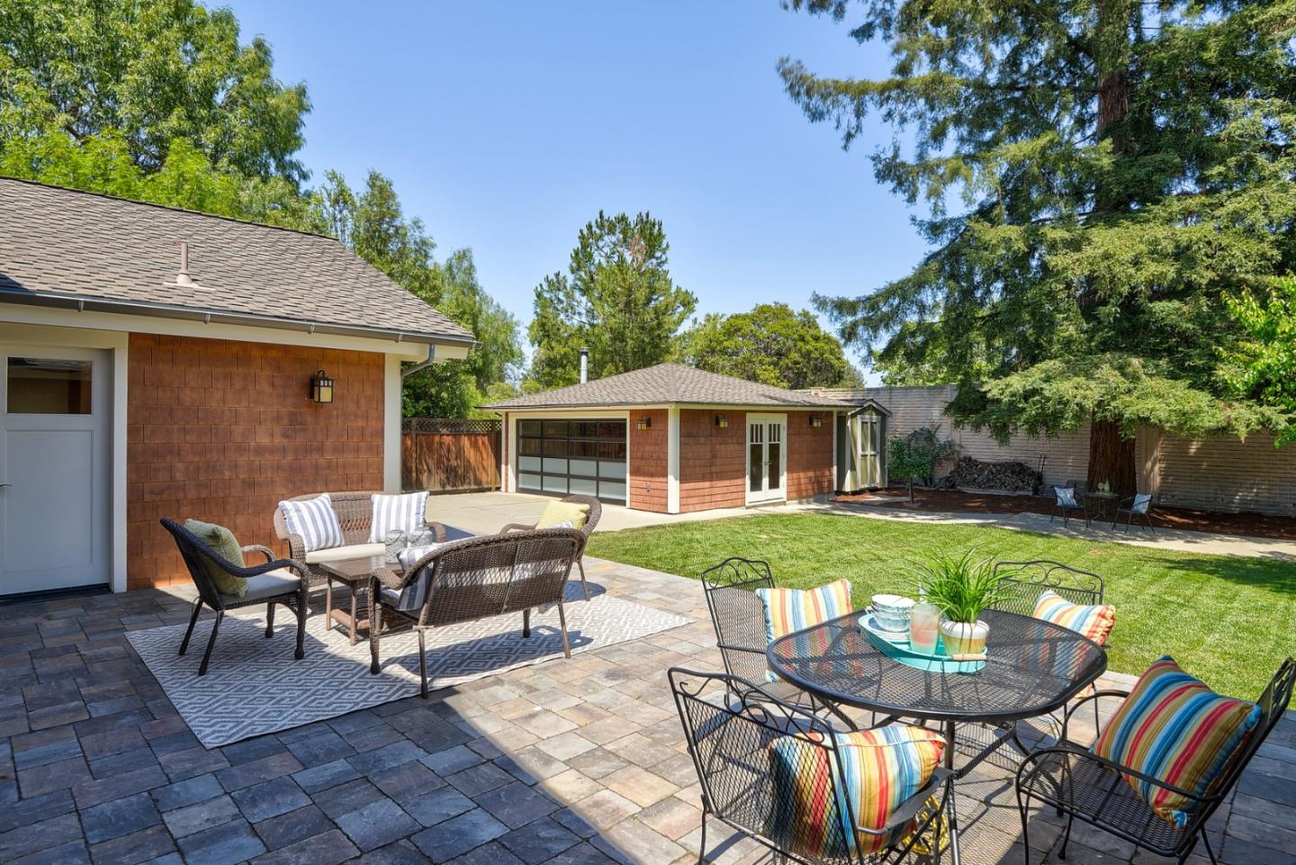 1035 Rilma Lane Los Altos, CA 94022 - Photo 31 of 41 a view of a patio with table and chairs with wooden fence and plants