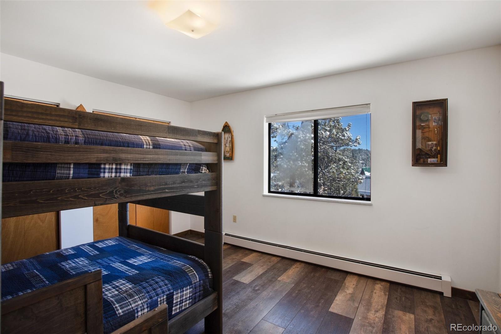 170 Ridge Road Divide, CO 80814 - Photo 23 of 50 a bedroom with a bed and wooden floor