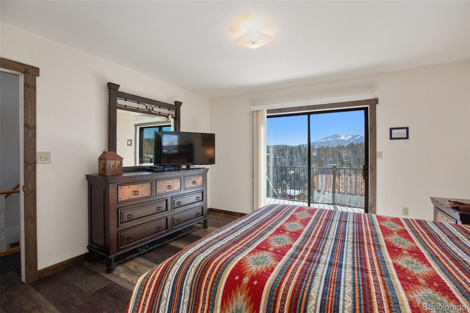 170 Ridge Road Divide, CO 80814 - Photo 26 of 50 a bedroom with a bed and a flat screen tv