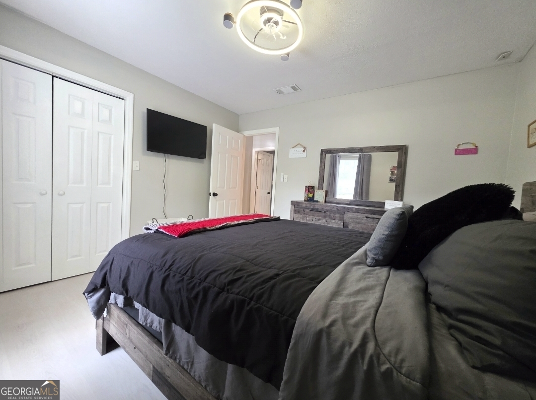 110 Maggie Court Leesburg, GA 31763 - Photo 47 of 64 a bedroom with a bed and a flat tv screen