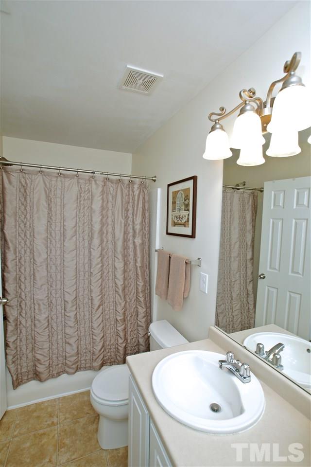 2161 Metacomet Way Raleigh, NC 27604 - Photo 14 of 21 a bathroom with a sink a toilet a mirror and shower curtain
