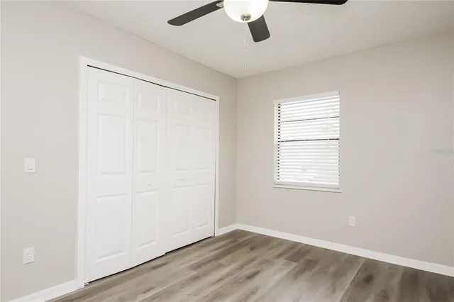 an empty room with a window and a ceiling fan