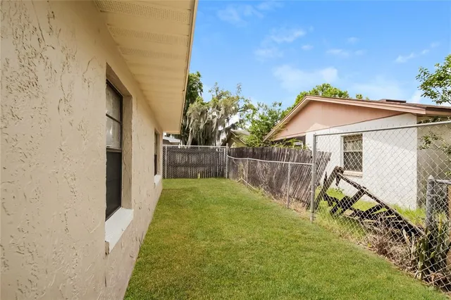 a view of an house with backyard and furniture
