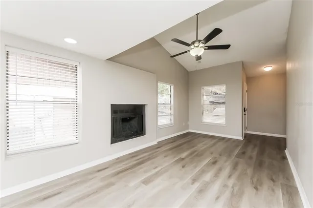 a view of an empty room with a window and a ceiling fan