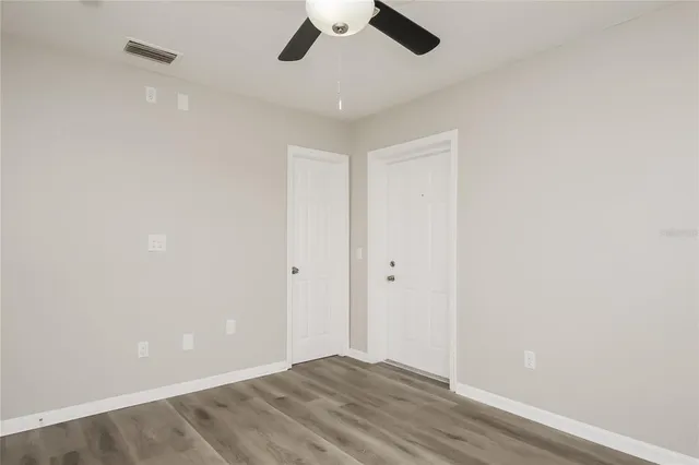 a view of room with hardwood floor and ceiling fan
