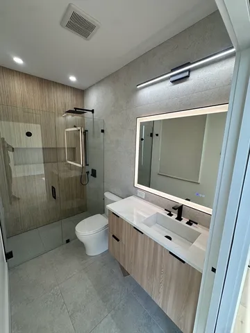 a bathroom with a sink a toilet and shower