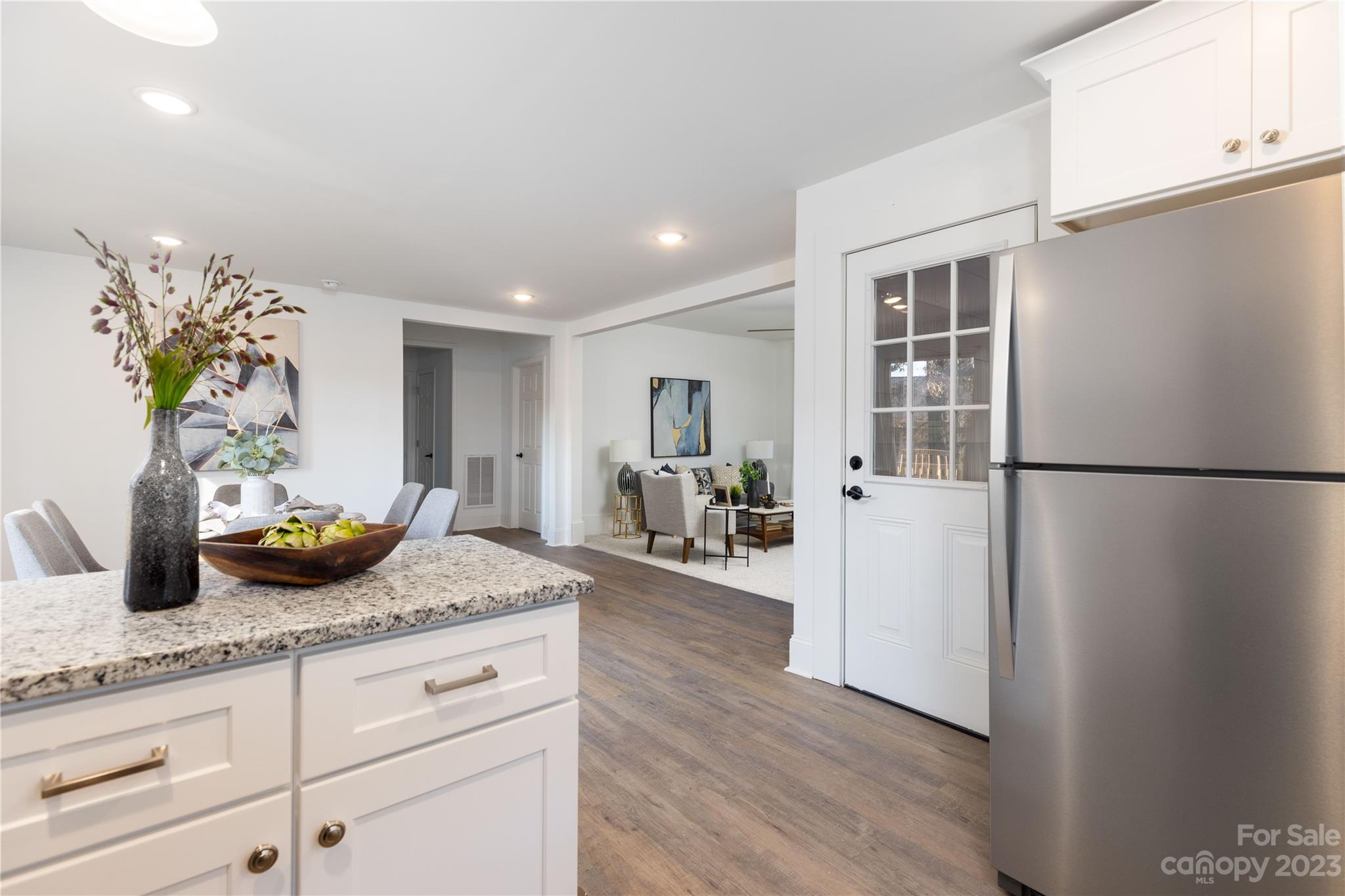 201 Hicks Circle Mount Holly, NC 28120 - Photo 11 of 23 a kitchen with granite countertop a refrigerator a stove a dining table and chairs with wooden floor