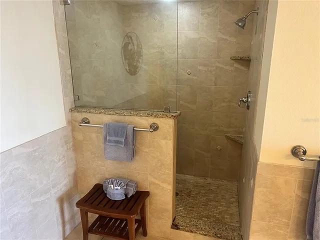 a bathroom with a granite countertop shower a sink and a stove