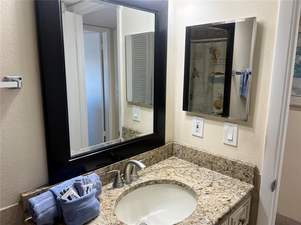 1001 Point Of Rocks Road, Unit 609 Sarasota, FL 34242 - Photo 5 of 41 a bathroom with a granite countertop sink and a mirror