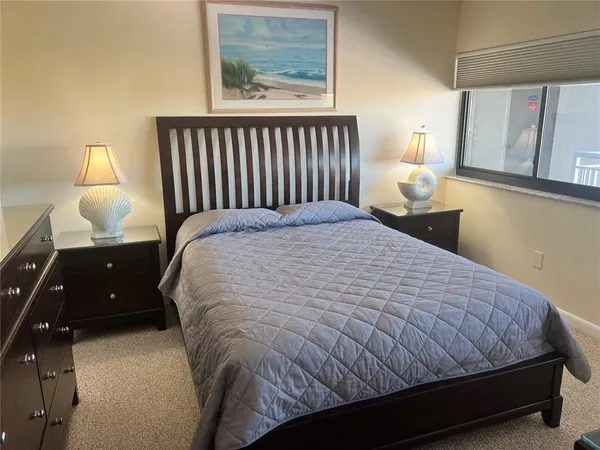 a large bed sitting in a bedroom next to a window