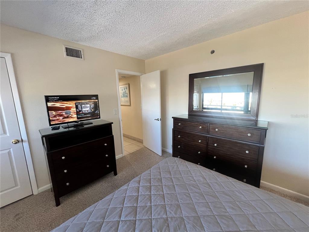 1001 Point Of Rocks Road, Unit 609 Sarasota, FL 34242 - Photo 7 of 41 a living room with a dresser and a mirror