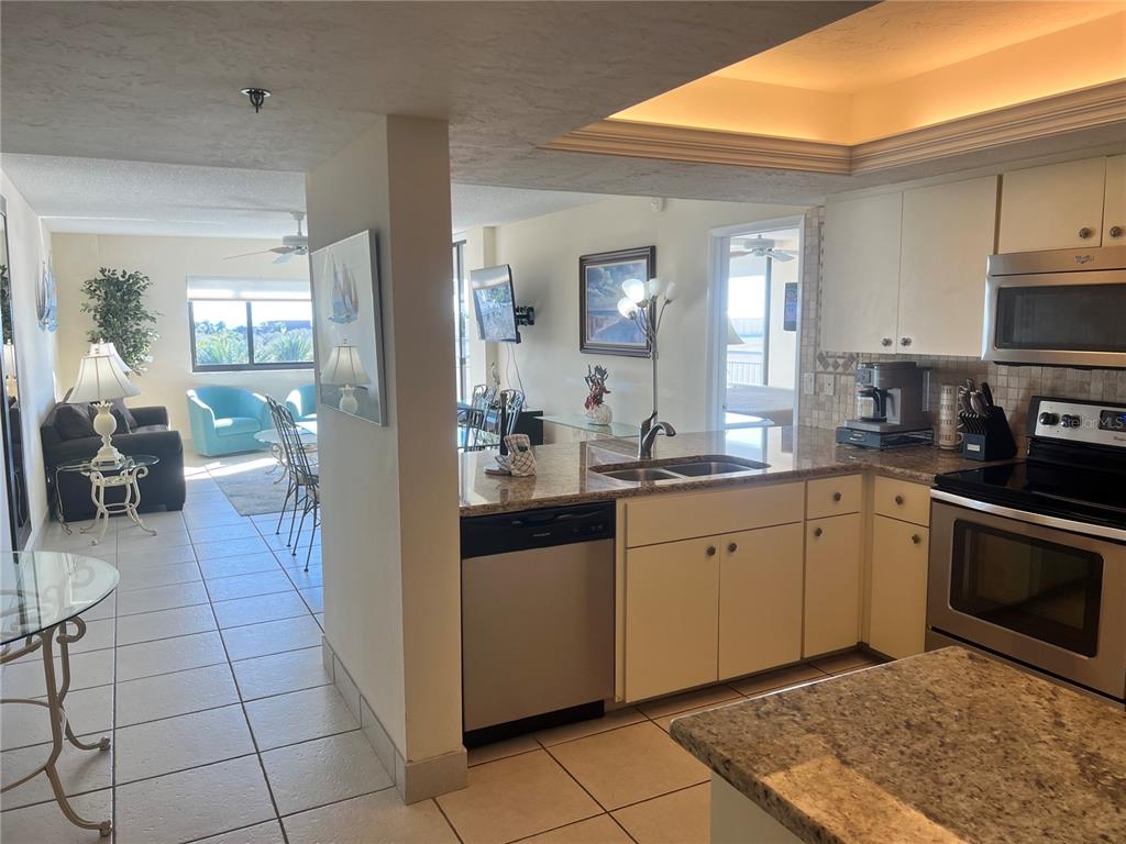 1001 Point Of Rocks Road, Unit 609 Sarasota, FL 34242 - Photo 8 of 41 a kitchen with stainless steel appliances granite countertop a sink and cabinets