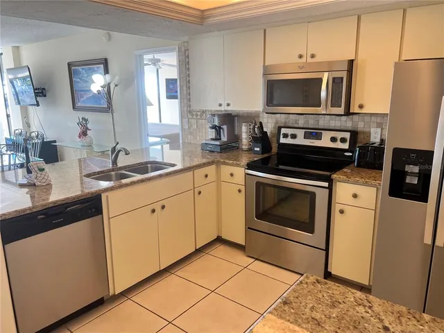 a kitchen with cabinets stainless steel appliances a sink and a counter space