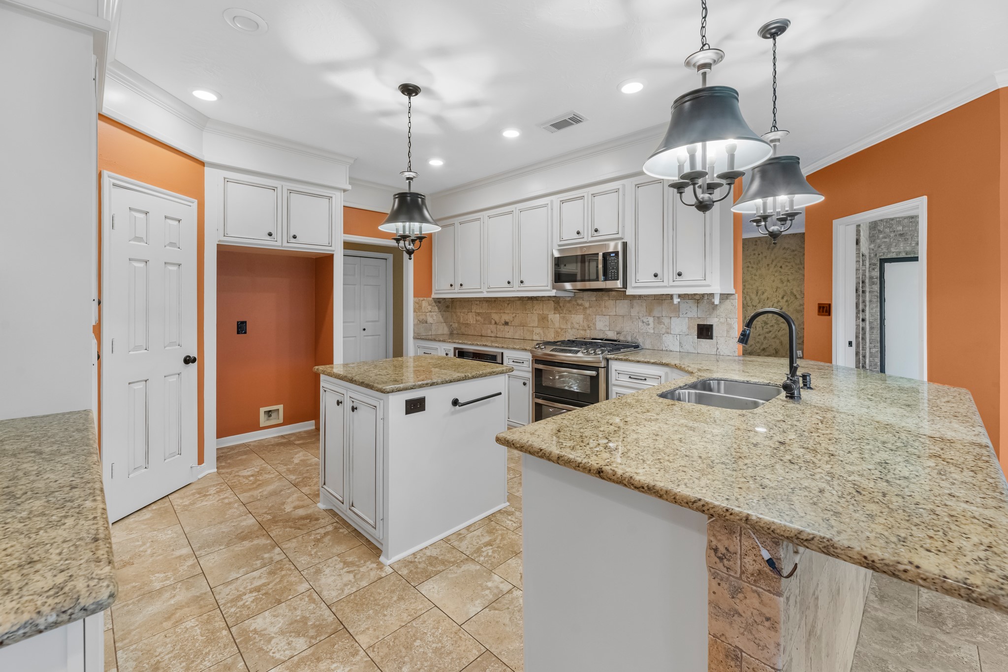 17126 County Road 39 Rosharon, TX 77583 - Photo 22 of 47 a kitchen with kitchen island granite countertop a sink a center island a stove a refrigerator and a chandelier