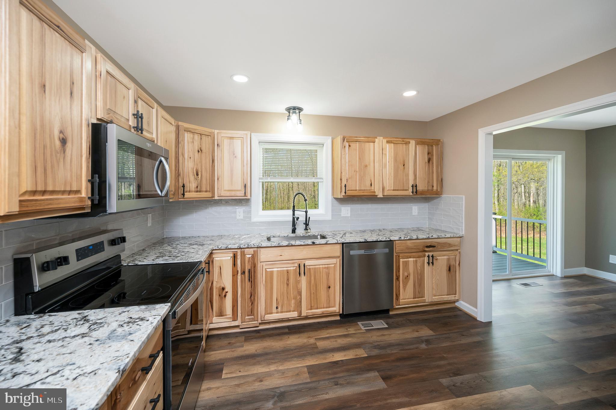 13452 Post Oak Road Spotsylvania, VA 22551 - Photo 29 of 56 a kitchen with stainless steel appliances granite countertop a sink stove and cabinets
