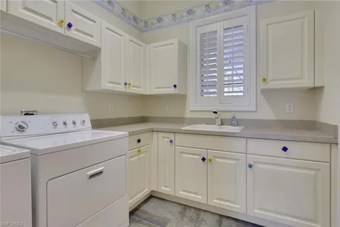 a kitchen with cabinets appliances a sink and a window