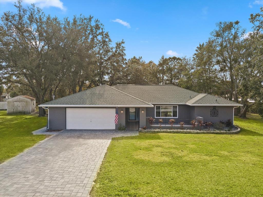 8426 Belmont Road Spring Hill, FL 34606 - Photo 1 of 1 Drone shot of the exterior of the home highlighting the very large custom pavered driveway and matching pavered front porch area