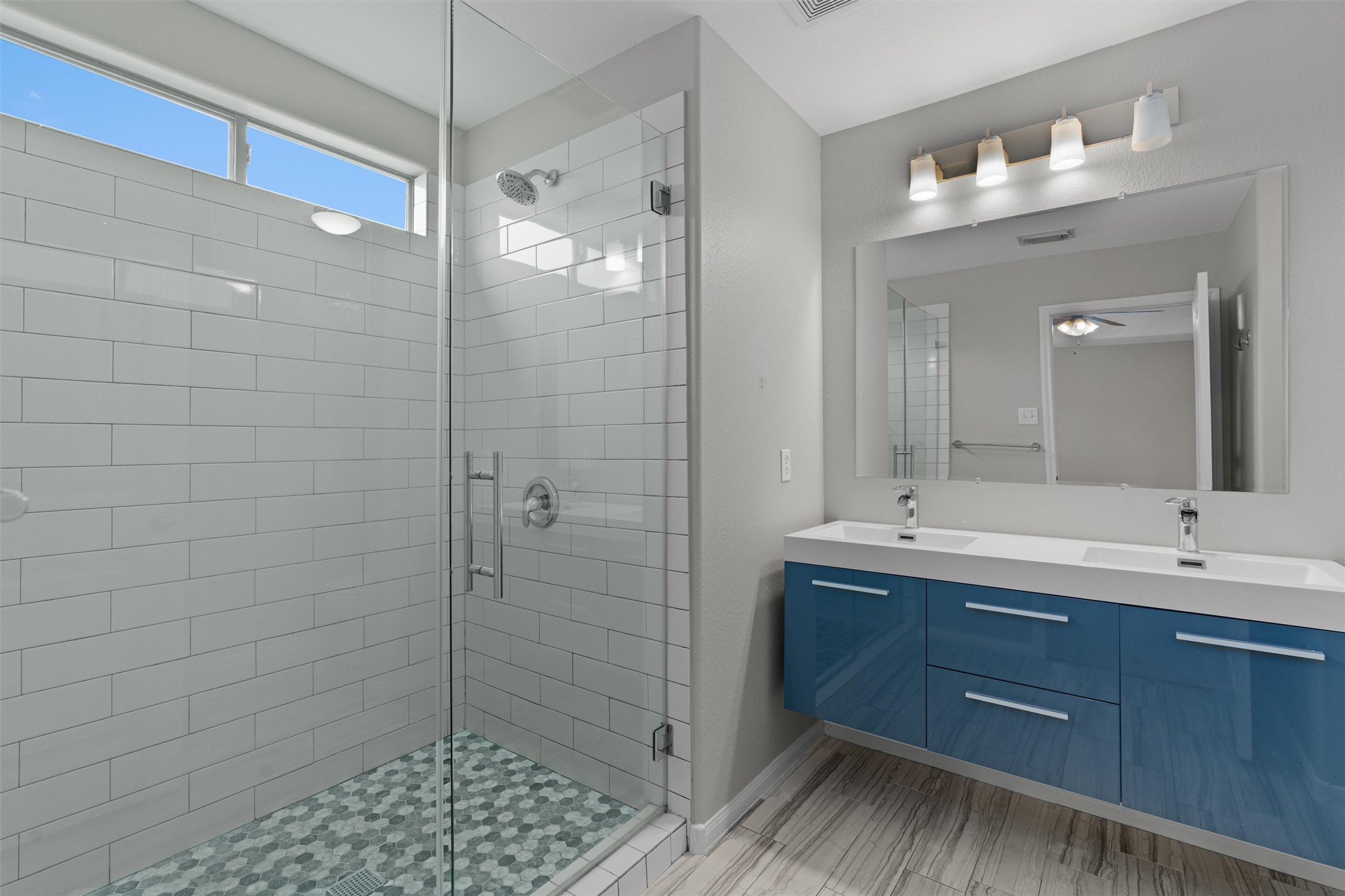 2240 Independence Drive, Unit A83 Austin, TX 78745 - Photo 21 of 34 a bathroom with a double vanity sink a large mirror and shower