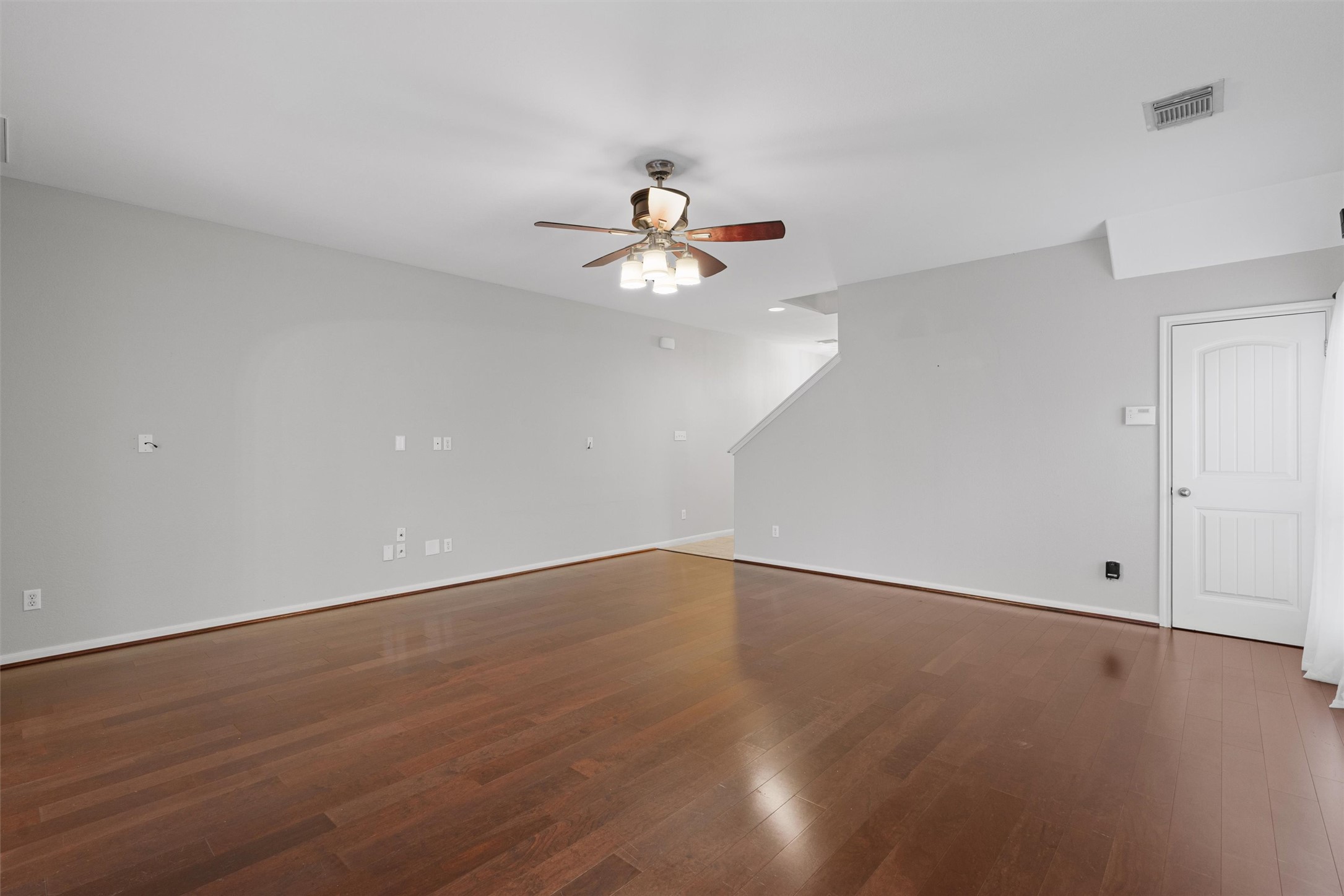 2240 Independence Drive, Unit A83 Austin, TX 78745 - Photo 6 of 34 a view of an empty room with chandelier fan and wooden floor