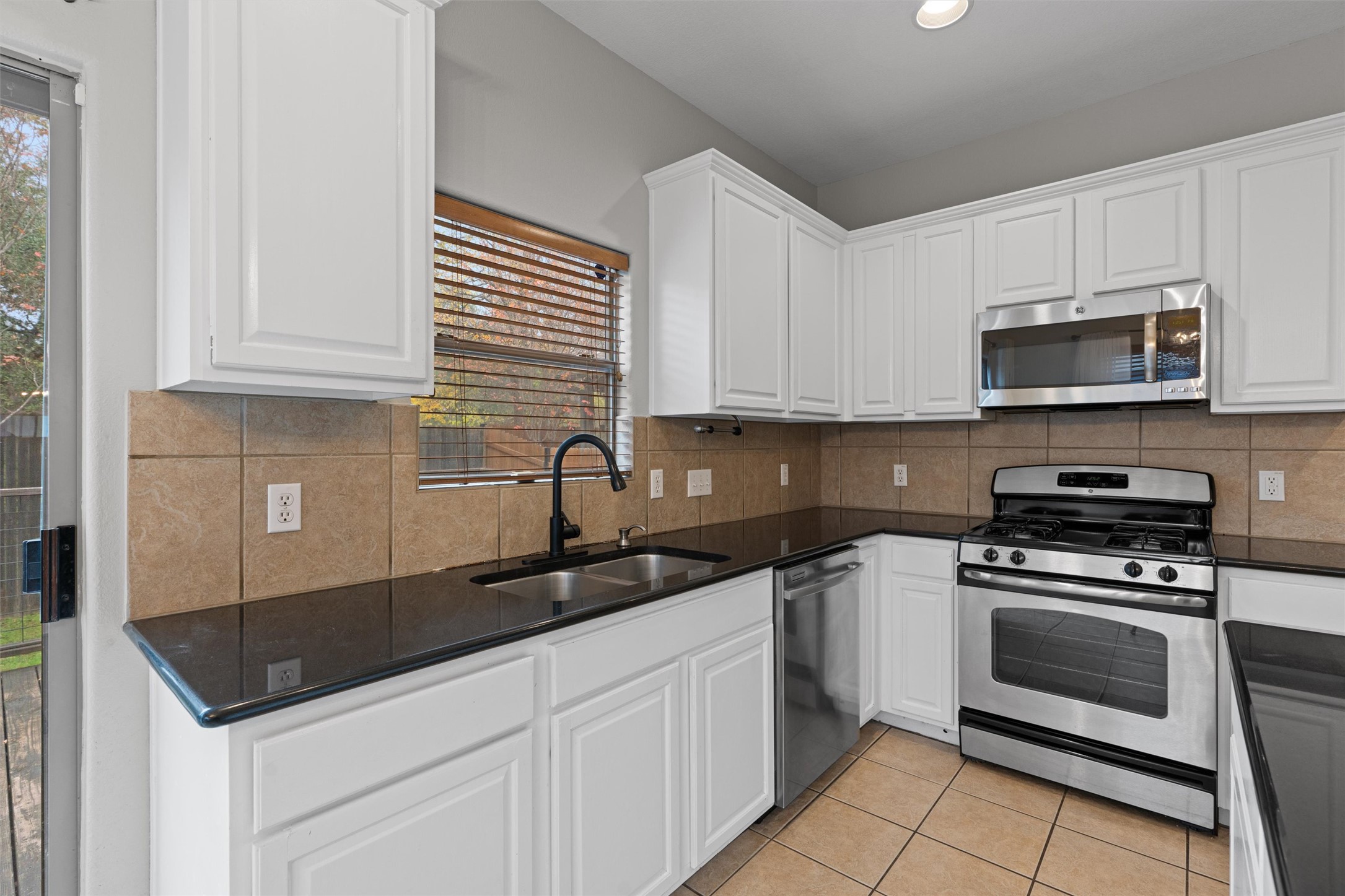 2240 Independence Drive, Unit A83 Austin, TX 78745 - Photo 9 of 34 a kitchen with sink a microwave and cabinets