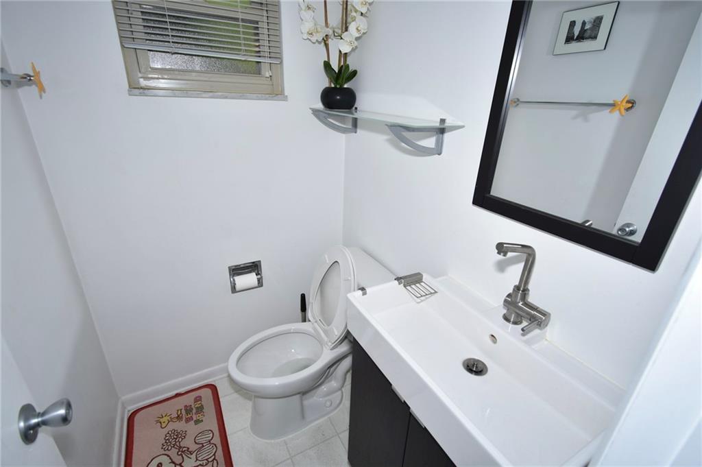 435 Elmer Street Edgewood, PA 15218 - Photo 8 of 16 a bathroom with a sink a toilet and a mirror