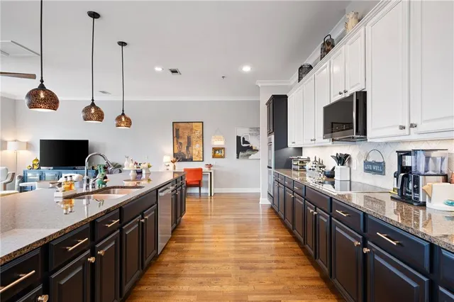 a large kitchen with kitchen island lots of counter space a sink a window and stainless steel appliances