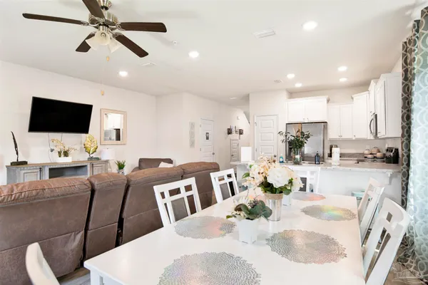 a living room with stainless steel appliances furniture a fireplace and a flat screen tv