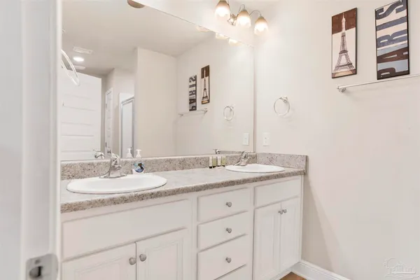 a bathroom with a granite countertop sink a large mirror and vanity