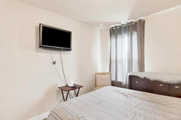 a bedroom with a bed and a flat screen tv