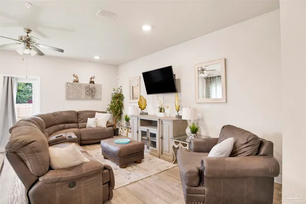 a living room with furniture a flat screen tv and a fireplace