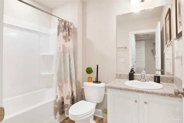 a bathroom with a granite countertop sink a toilet and shower