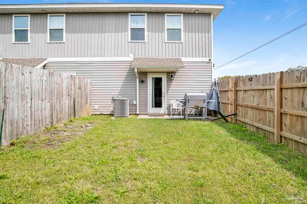 a view of backyard of house with wooden deck and seating