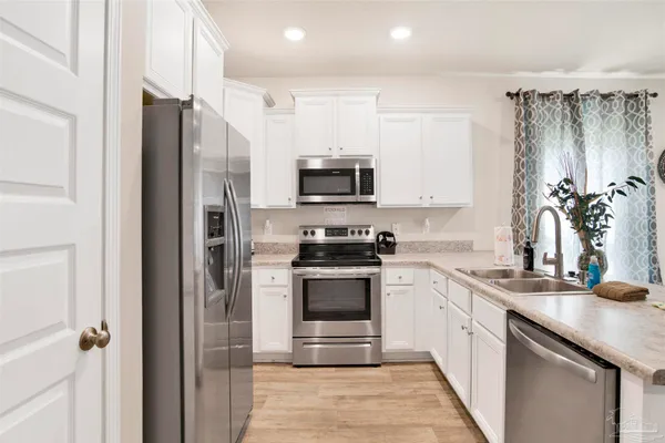 a kitchen with stainless steel appliances granite countertop a refrigerator and a sink