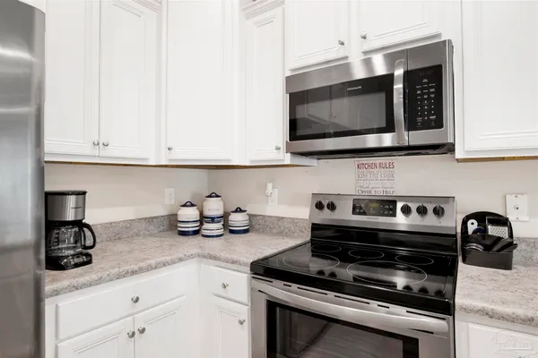 a kitchen with appliances a sink and cabinets