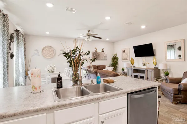 a kitchen with a faucet a sink and a flat screen tv