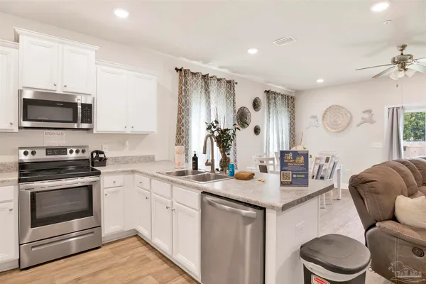 a kitchen with stainless steel appliances granite countertop a stove a sink and a microwave