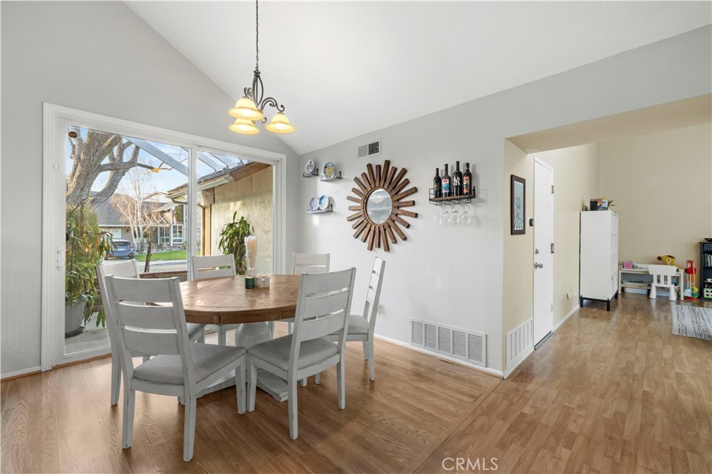 23716 Rotunda Road Valencia, CA 91355 - Photo 11 of 39 a dining room with furniture a chandelier and wooden floor