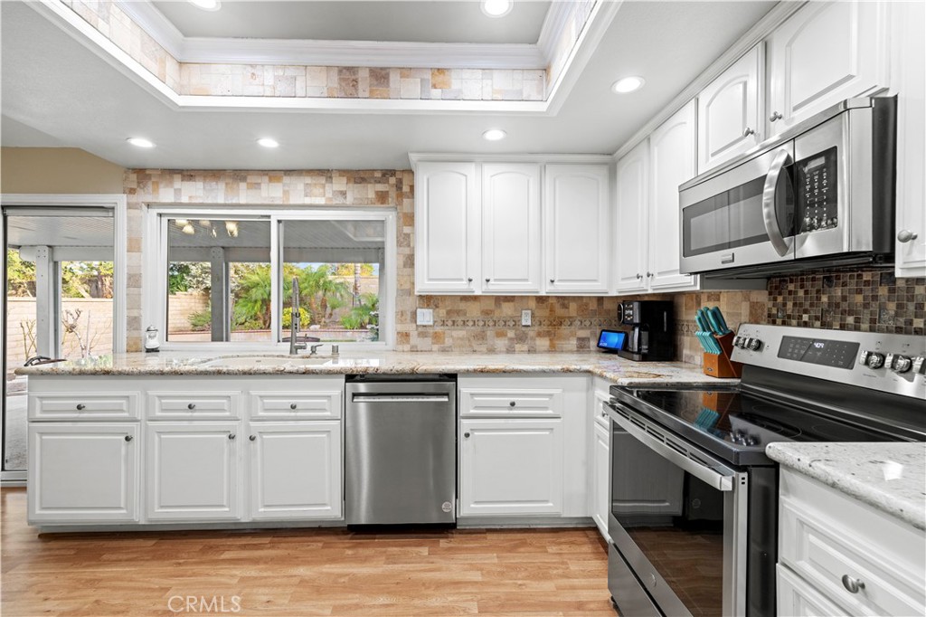 23716 Rotunda Road Valencia, CA 91355 - Photo 12 of 39 a kitchen with stainless steel appliances granite countertop a stove and a sink