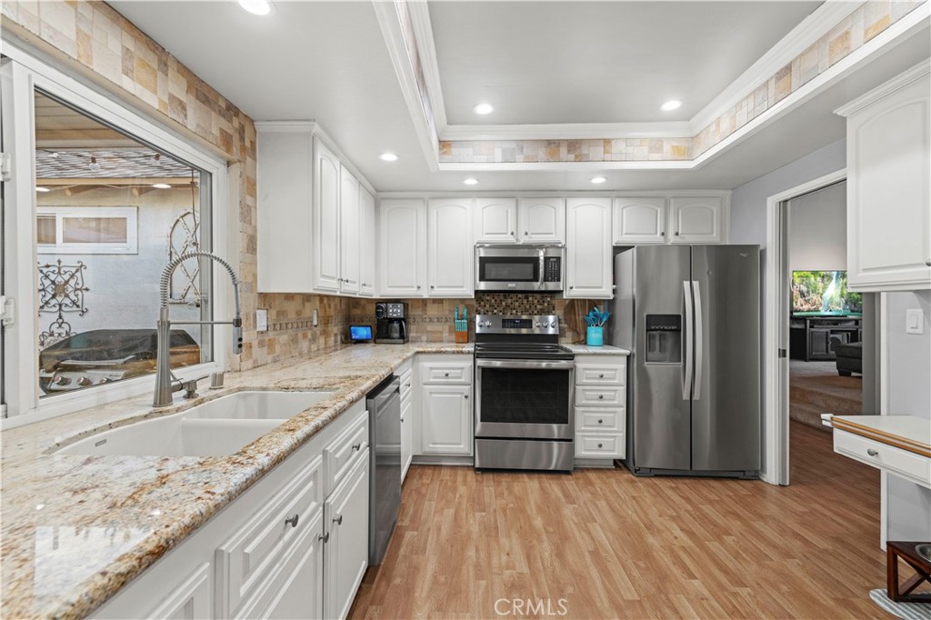 23716 Rotunda Road Valencia, CA 91355 - Photo 14 of 39 a kitchen with kitchen island granite countertop a sink appliances cabinets and counter space
