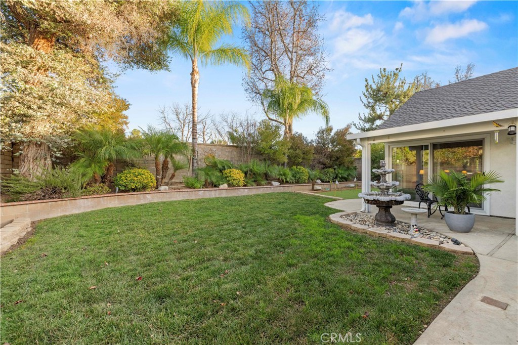 23716 Rotunda Road Valencia, CA 91355 - Photo 35 of 39 a view of a patio with table and chairs potted plants and palm tree