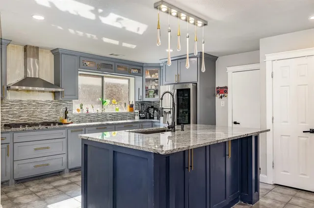 a kitchen with stainless steel appliances granite countertop a sink stove and refrigerator