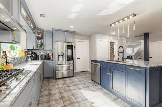 a kitchen with stainless steel appliances a refrigerator sink and stove