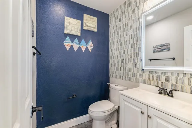 a bathroom with a sink a toilet and a mirror