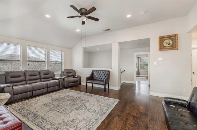 a living room with furniture and a wooden floor