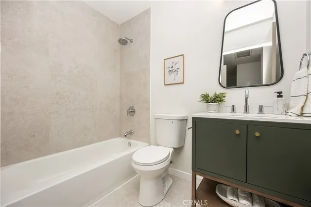 a bathroom with a toilet a sink a mirror and bathtub